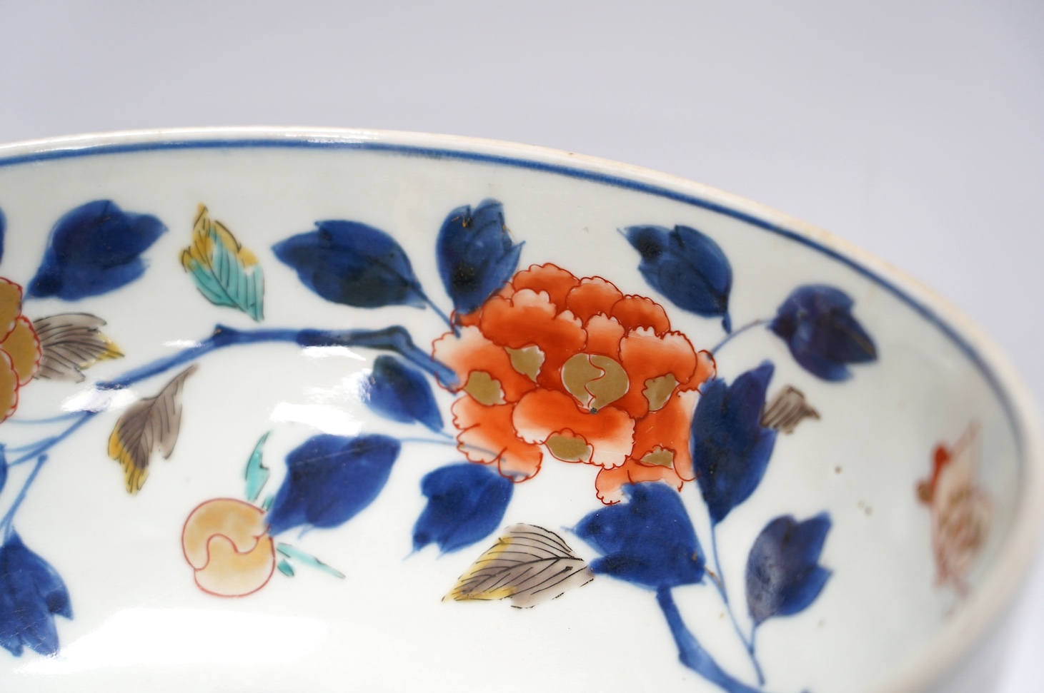 A Japanese Arita polychrome bowl, c.1700, diameter 24.5cm, height 12.5cm, on a carved hardwood stand. Condition - large overglazed open firing crack to foot, otherwise good